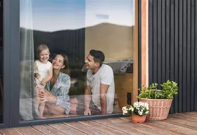 Familie sitzt zu Hause vor dem Fenster